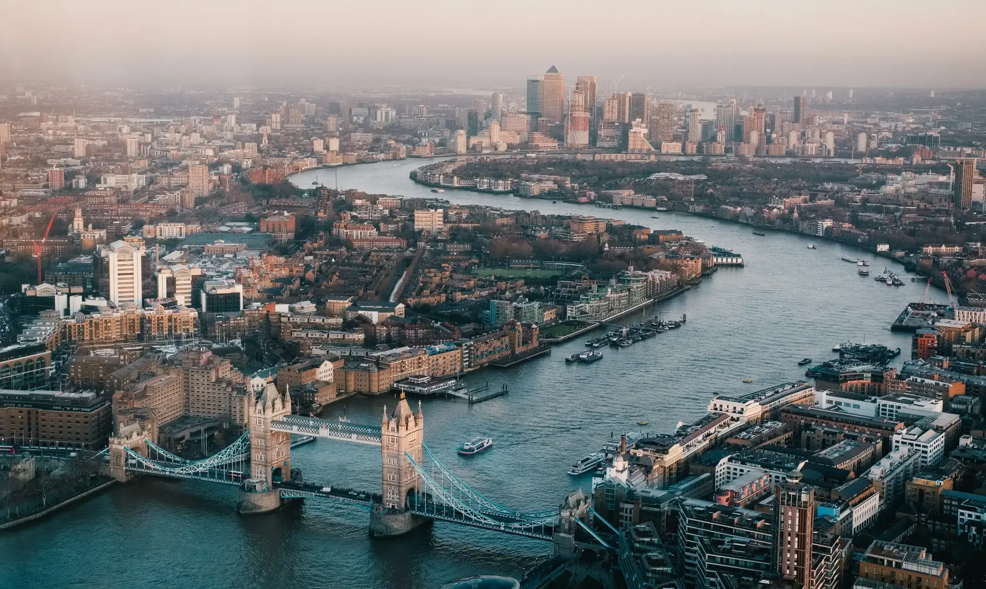 The Thames from above at dusk, looking east over Tower Bridge towards Canary Wharf.