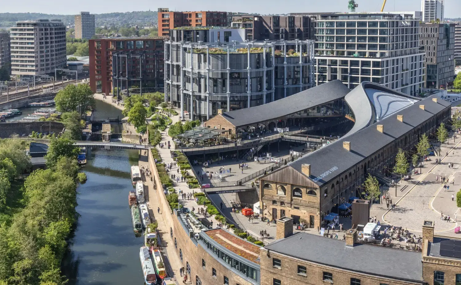 Coal Drops Yard and the Gasholders at King's Cross, seen from above with narrowboats moored along Regent's Canal.